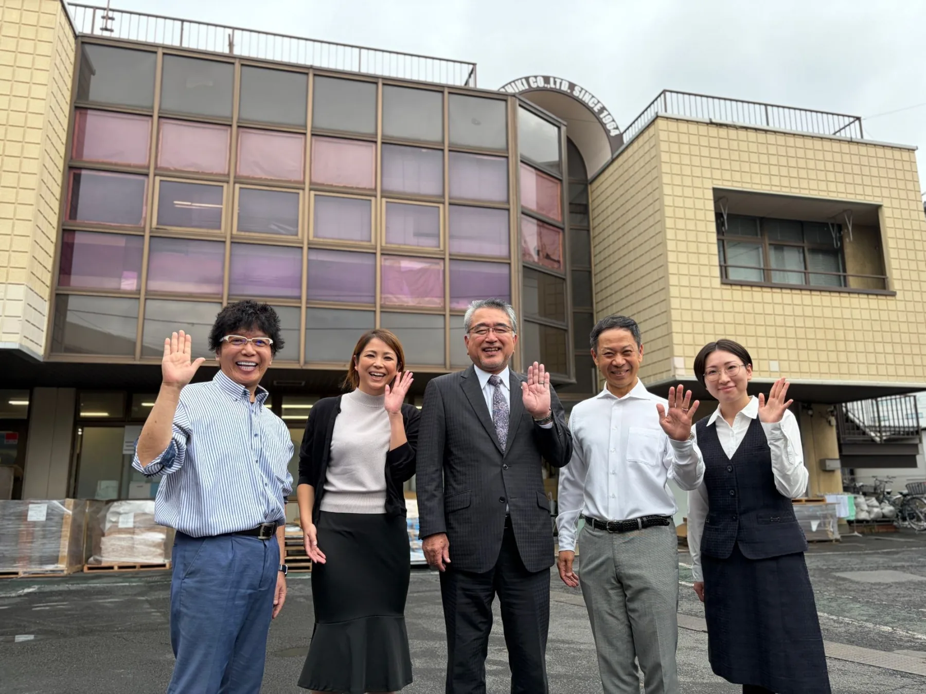 社屋の前で手を振る森紙器の社員たち